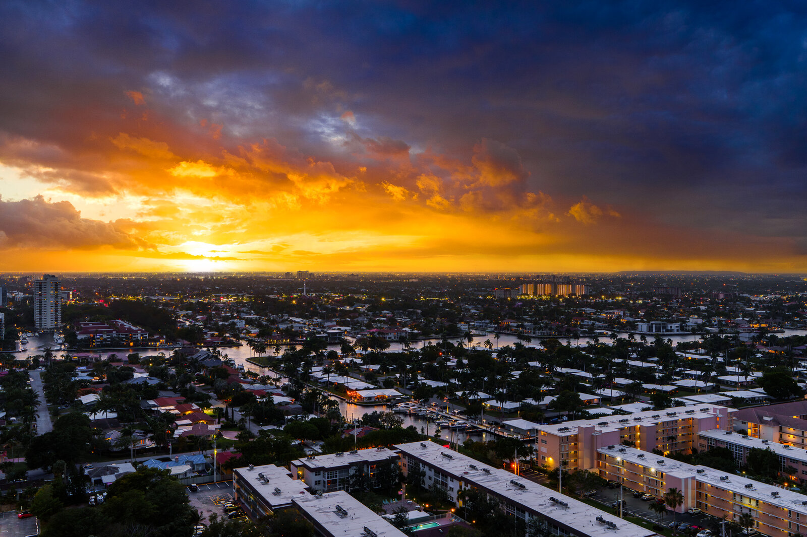 Urban skyline at dusk with a fiery orange sunset composited in